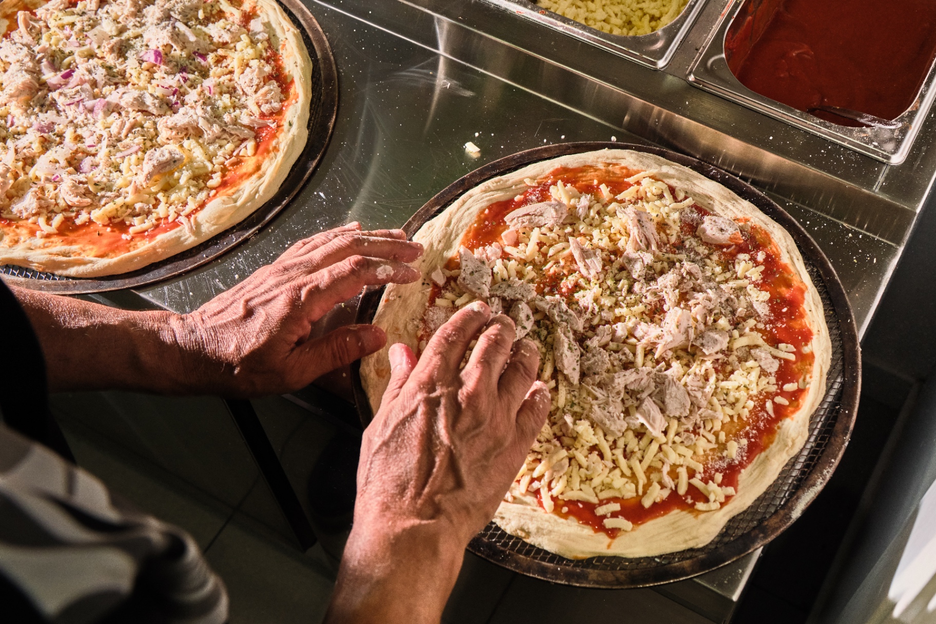 Pizza recién montada antes de entrar al horno de leña